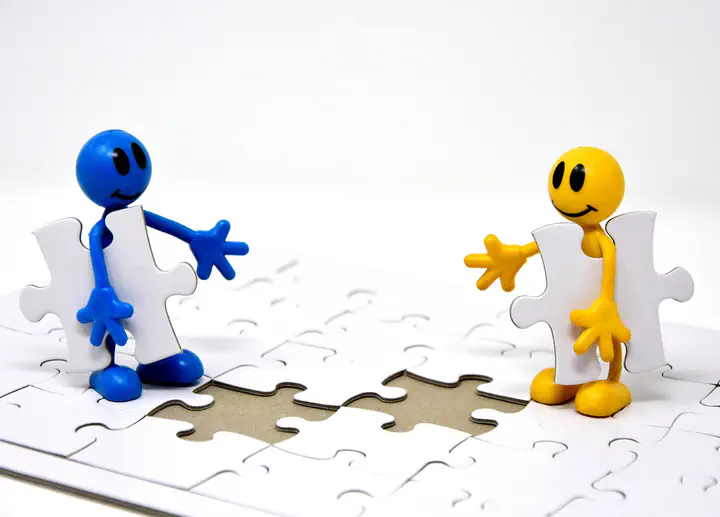 Zwei Figuren bringen die letzten beiden Teile für eins Puzzle.